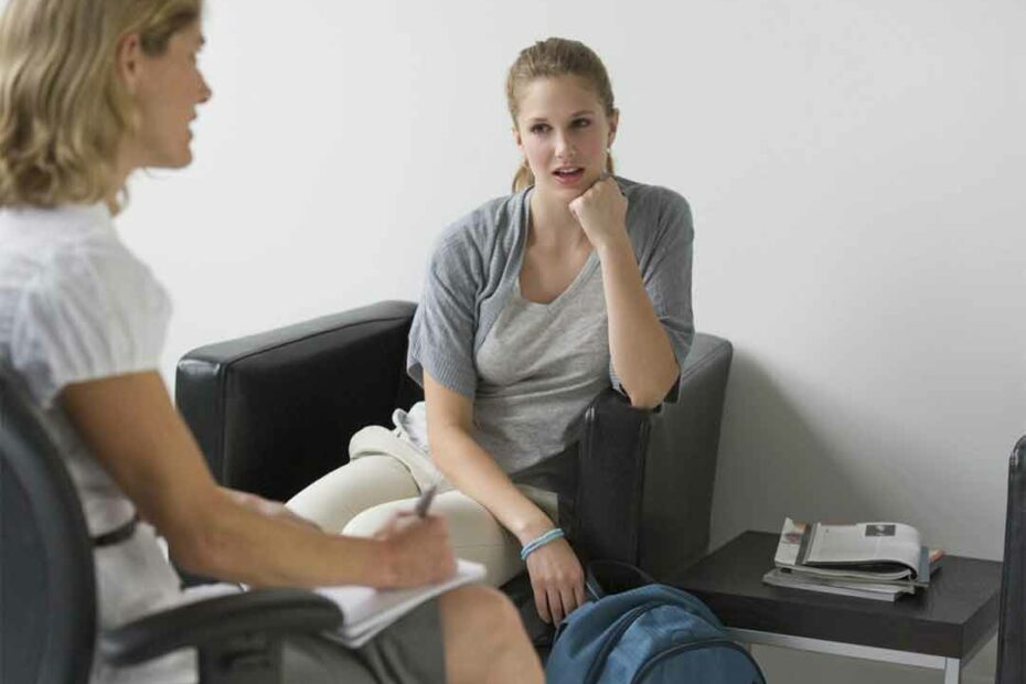 Young woman discussing financial options for residential treatment with an admissions counselor in a serene office environment.